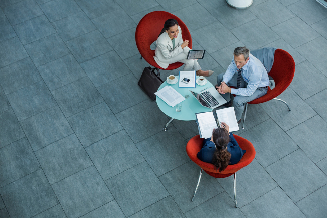 High angle view of businesspeople discussing strategy at coffee table in office