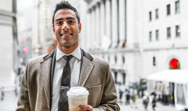 Businessman with coffee mug on wall street